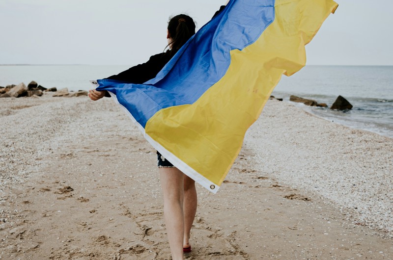 Pige med ukrainsk flag på strand