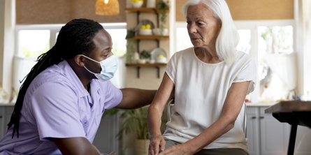 Male social worker taking care of an old woman